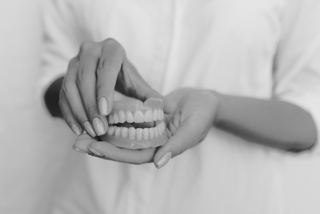 Woman holding dentures on her hand